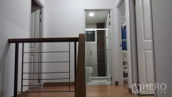 บ้าน ให้เช่าหรือขายในPrawet, Bangkok - โถงบันไดชั้นบนพร้อมราวไม้ มองเห็นประตูห้องน้ำและห้องนอน