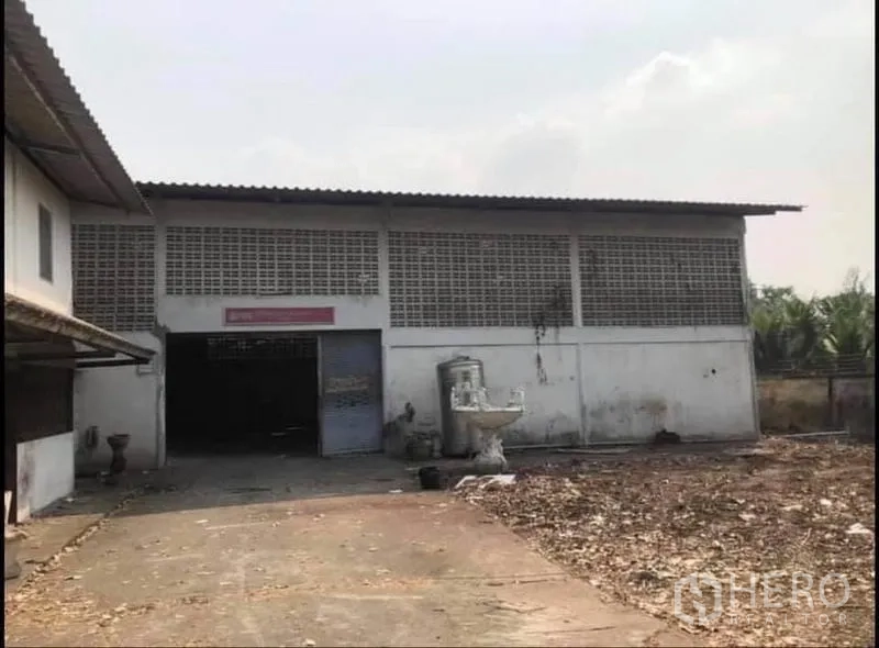 工厂 出售在Nong Chok, Bangkok - 单层厂房外立面，卷帘门与铺装装卸区。