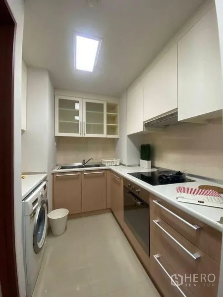 คอนโด ให้เช่าหรือขายในPhra Khanong, Bangkok - ครัวแคบยาวพร้อมเตาอบ เตาไฟฟ้า อ่างล้างจาน และเครื่องซักผ้า