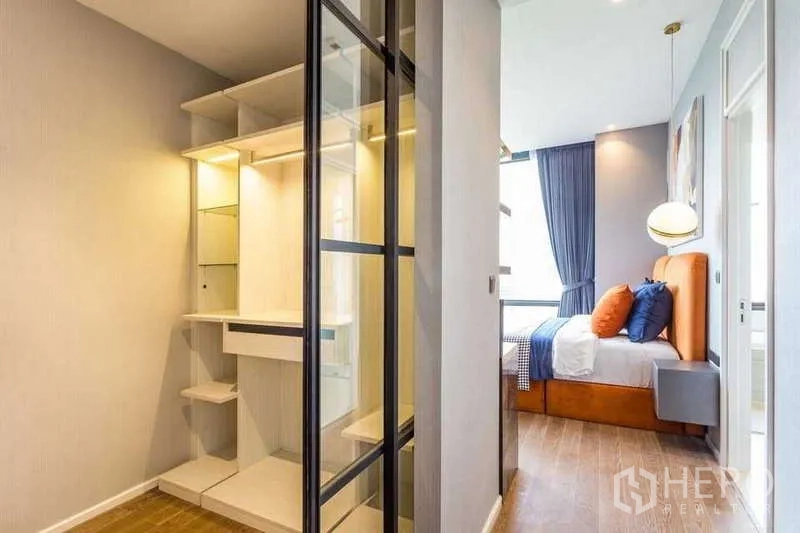 Condominium for rent in Pathum Wan, Bangkok - Walk-in closet with glass sliding doors leading to the bedroom.