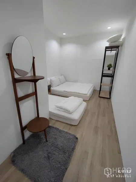 带办公室的家 出租 - 狭长卧室，两张地铺床垫，立式梳妆镜与地毯。