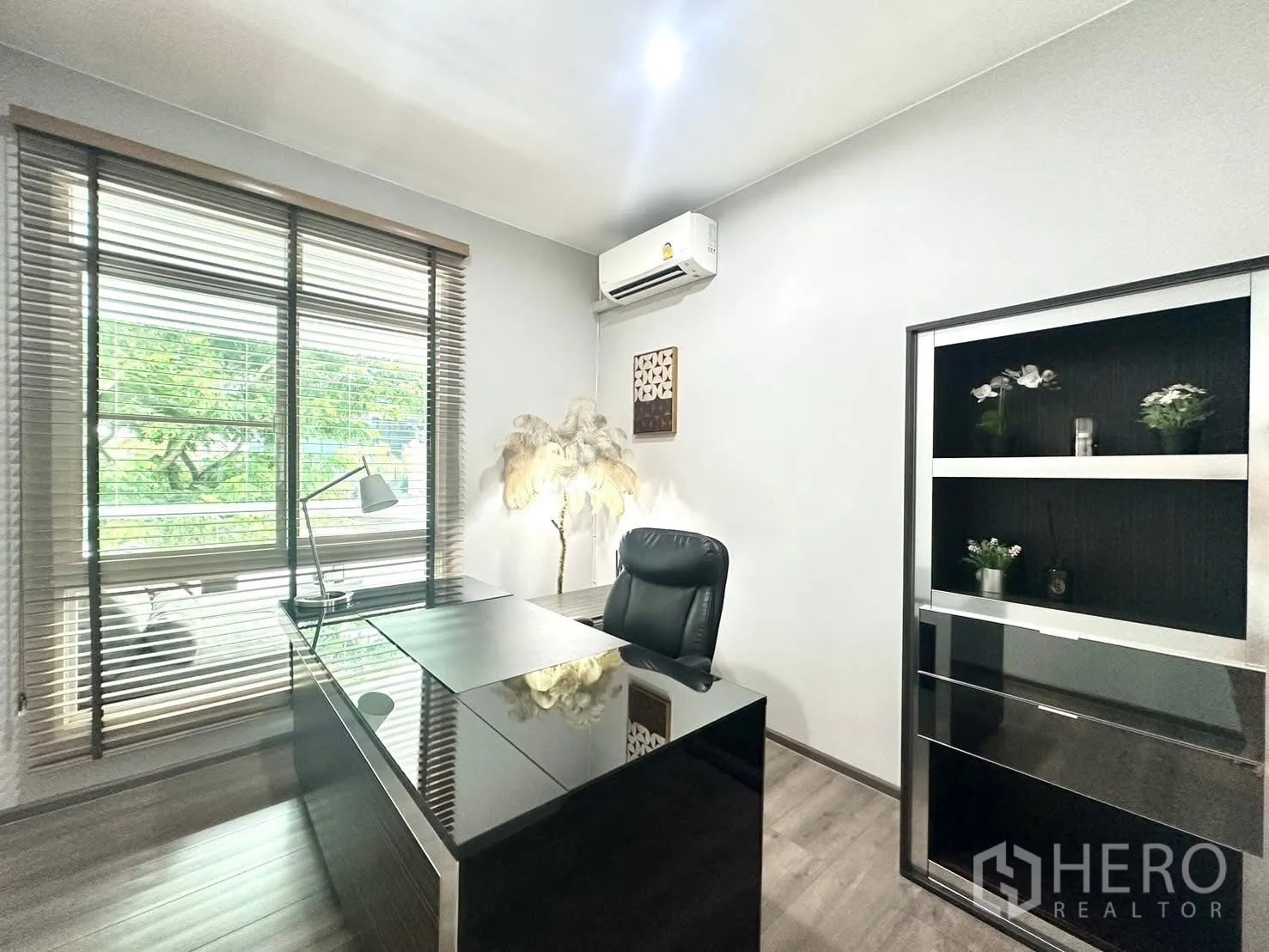 บ้านเดี่ยว for rent in Bang Phli, Samut Prakan - ห้องทำงานมีโต๊ะทำงานขนาดใหญ่ ชั้นวาง และวิวต้นไม้ผ่านหน้าต่าง.