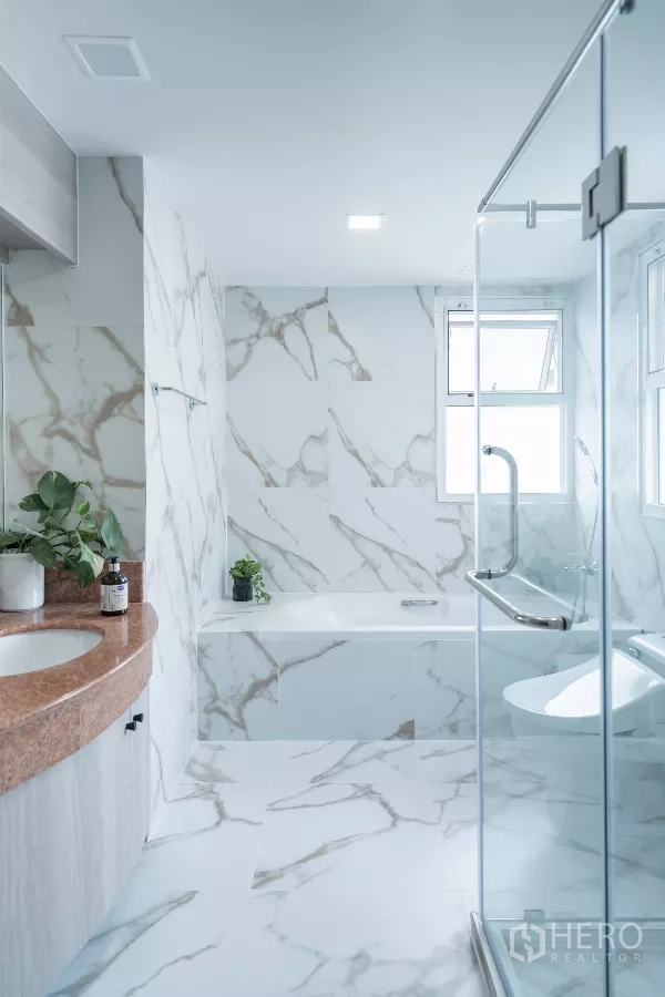 Apartment for rent - Light-filled bathroom with bathtub and a glass shower enclosure.