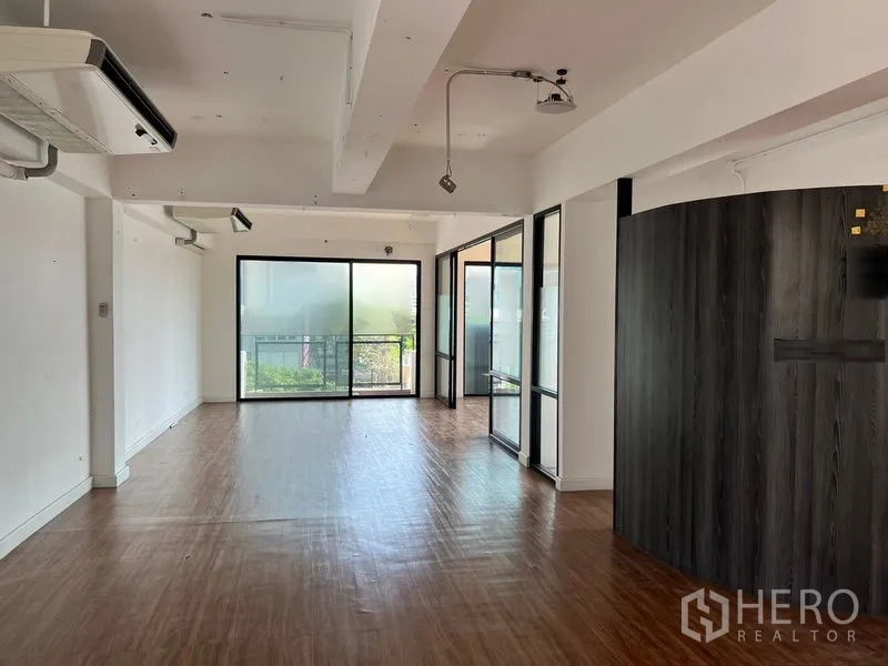 Office Space for rent in Sathon, Bangkok - Bright open-plan office with wood flooring, ceiling AC, and glass-partitioned rooms.
