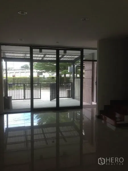 สำนักงานที่บ้าน ให้เช่าในBang Phli, Samut Prakan - พื้นที่ชั้นล่างมองออกไปยังประตูกระจกบานเลื่อนและลานจอดรถที่มีรั้ว