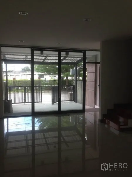 สำนักงานที่บ้าน ให้เช่าในBang Phli, Samut Prakan - พื้นที่ชั้นล่างมองออกไปยังประตูกระจกบานเลื่อนและลานจอดรถที่มีรั้ว