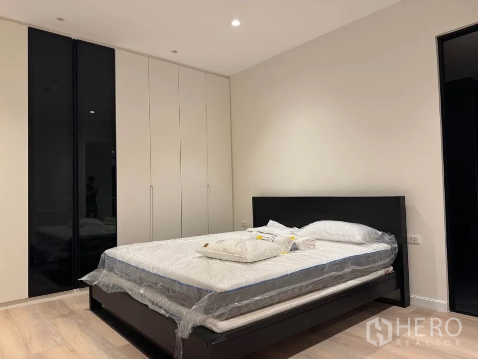 คอนโด for rent in Ratchathewi, Bangkok - ห้องนอนพร้อมที่นอนใหม่ เตียงสีดำ และตู้เสื้อผ้าสูงจรดเพดาน