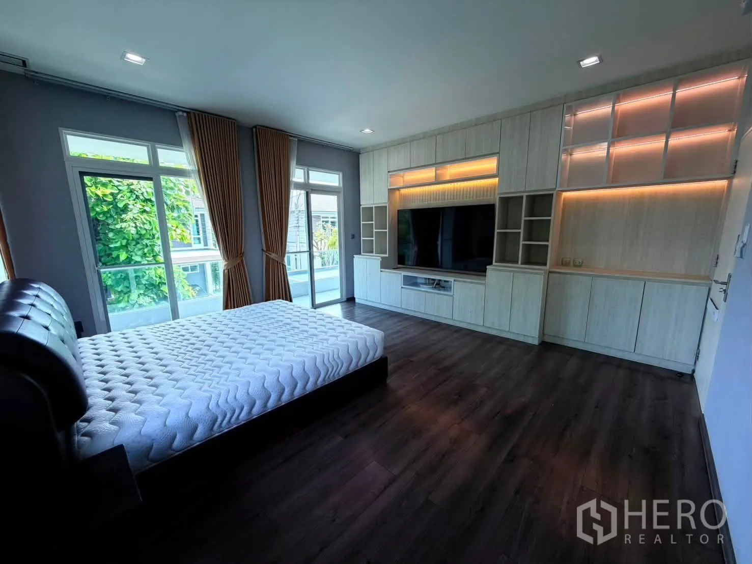 Detached House for rent in Bang Phli, Samut Prakan - Primary bedroom with king bed, large built‑in TV wall and balcony doors.