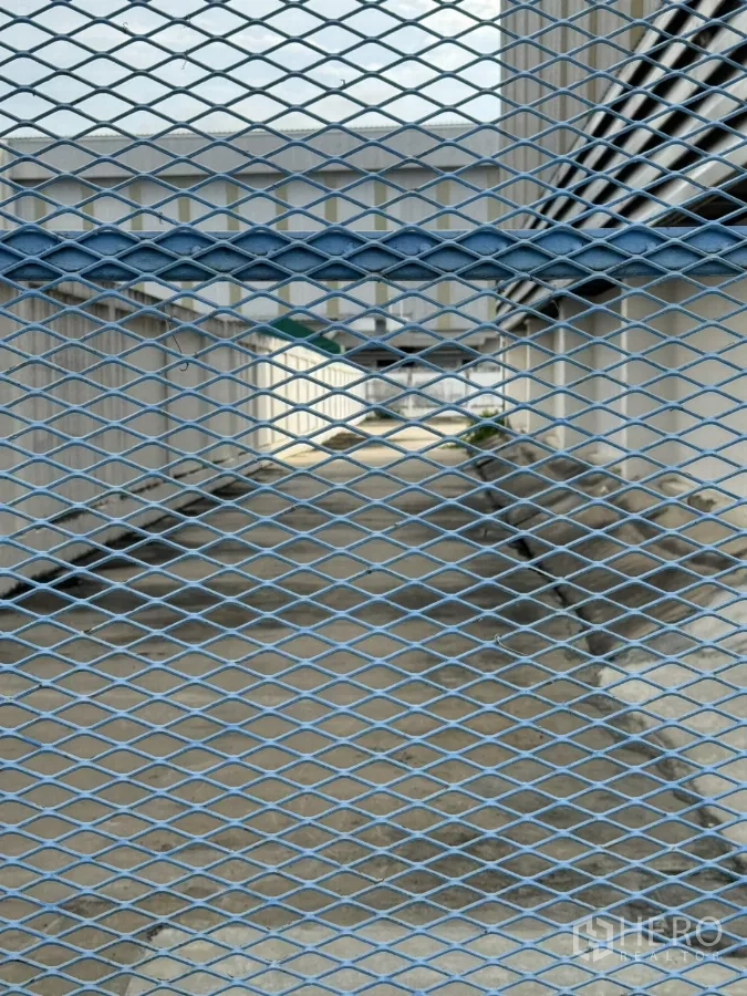 工厂 出租或出售在Bang Phli, Samut Prakan - 透过金属网看到建筑间的侧向通道。