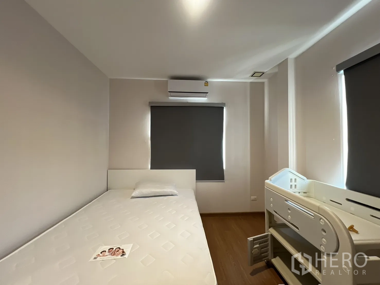 บ้านเดี่ยว for rent in Bang Kapi, Bangkok - ห้องนอนขนาดกะทัดรัดมีเตียงและเตียงเด็ก พร้อมม่านกันแสง.