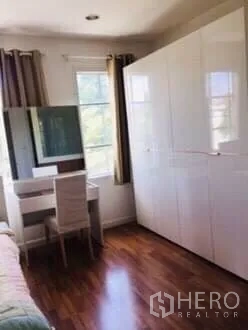 ทาวน์เฮาส์ ให้เช่าในBang Kapi, Bangkok - มุมห้องนอน ตู้เสื้อผ้าบานเงาสีขาว โต๊ะเครื่องแป้ง และหน้าต่างติดผ้าม่าน