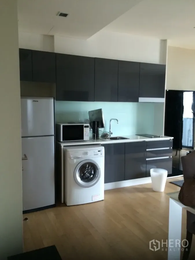คอนโด ให้เช่าในWatthana, Bangkok - ครัวบิวท์อินสมัยใหม่ ตู้สีเทามันวาว ตู้เย็น ไมโครเวฟ และเครื่องซักผ้า ในคอนโดย่านเอกมัย