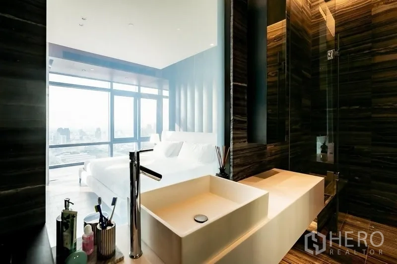 公寓 出售在Ratchathewi, Bangkok - 从浴室台盆望向卧室的玻璃隔断视角，旁为步入式淋浴间。