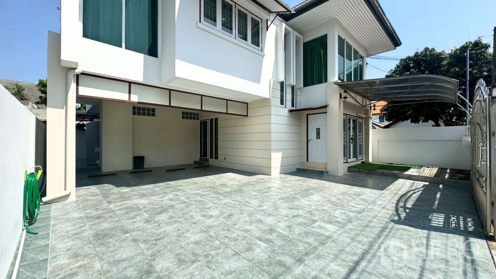 独栋房屋 for rent in Suan Luang, Bangkok - 宽敞的铺砖前院，设有带顶车位与房屋侧门。