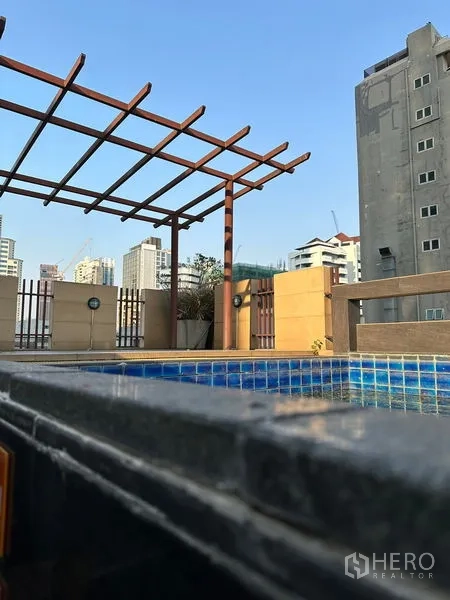 Apartment for rent in Khlong Toei, Bangkok - Rooftop swimming pool with pergola and a Bangkok city skyline backdrop.