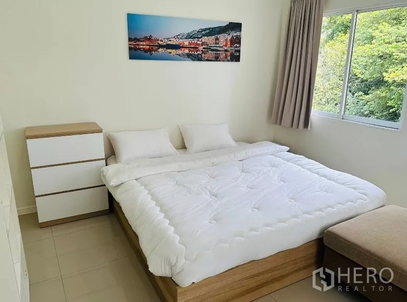 บ้าน ให้เช่า - ห้องนอนขนาดกะทัดรัด ผ้าปูขาว ลิ้นชัก และหน้าต่างวิวต้นไม้.