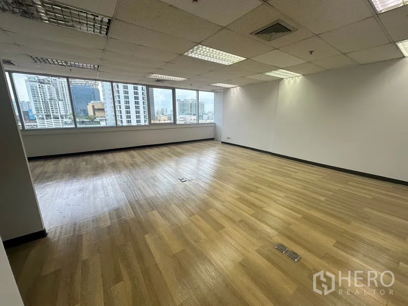 办公空间 出租在Phra Khanong, Bangkok - 转角办公区，落地大窗可观曼谷天际线，吊顶灯明亮。