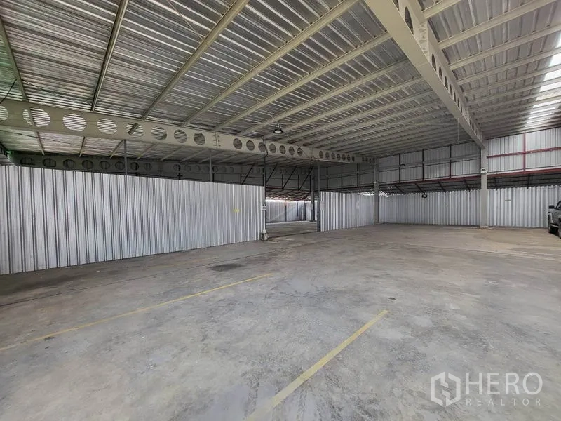 Warehouse for rent in Din Daeng, Bangkok - Open-plan warehouse interior with concrete floor, steel roof and marked bays for parking or loading.