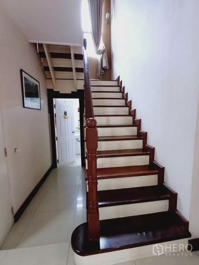 独立式住宅 出租或出售在Mueang Nonthaburi, Nonthaburi - 通往二层的木质楼梯与扶手。