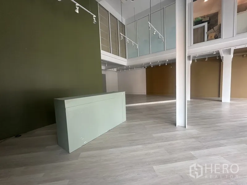 零售空间 出租在Khlong Toei, Bangkok - 接待或收银区，绿色特色墙与玻璃夹层。