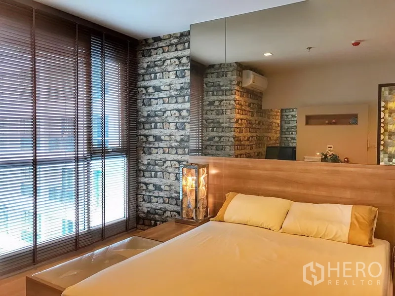 公寓 出租在Sathon, Bangkok - 舒适卧室，木质床头、砖纹特色墙与大面积百叶窗