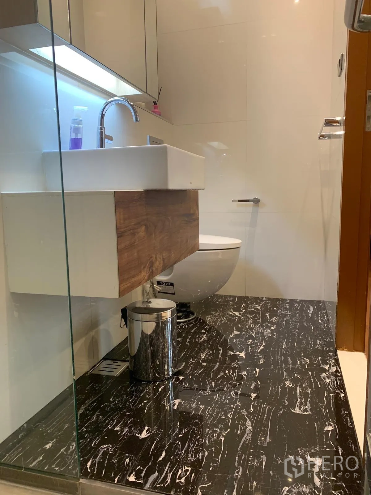 公寓 出售在Khlong Toei, Bangkok - 卫浴间，方形台盆、壁挂马桶与黑色大理石地面。