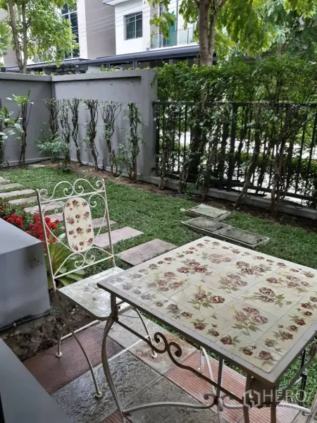 ทาวน์เฮาส์ ให้เช่าในBang Kapi, Bangkok - สวนส่วนตัวร่มรื่นพร้อมโต๊ะเก้าอี้เหล็กดัด พุ่มไม้และทางเดินหิน