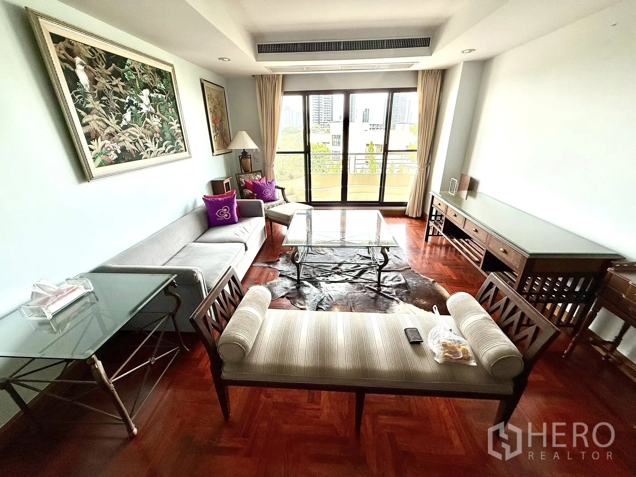 Condominium for rent in Sathon, Bangkok - Living area looking toward the balcony with city view and natural light.