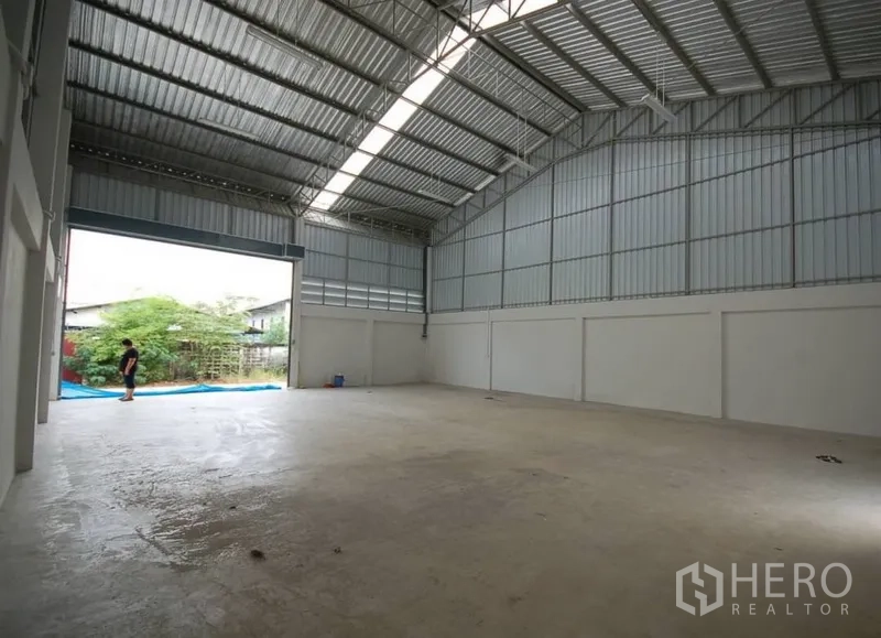 คลังสินค้า ให้เช่าในNonthaburi - ภายในโกดังโล่ง เพดานเมทัลชีทสูง มีแผงรับแสงธรรมชาติและประตูม้วนขนาดใหญ่