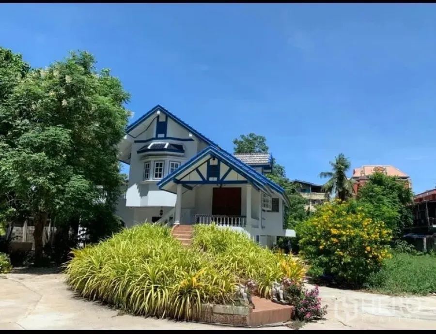 บ้าน ให้เช่าในKhlong San, Bangkok - ด้านหน้าบ้านทรงจั่วหลังคาสีน้ำเงิน พร้อมสวนจัดแต่งเขียวชอุ่มและท้องฟ้าใส