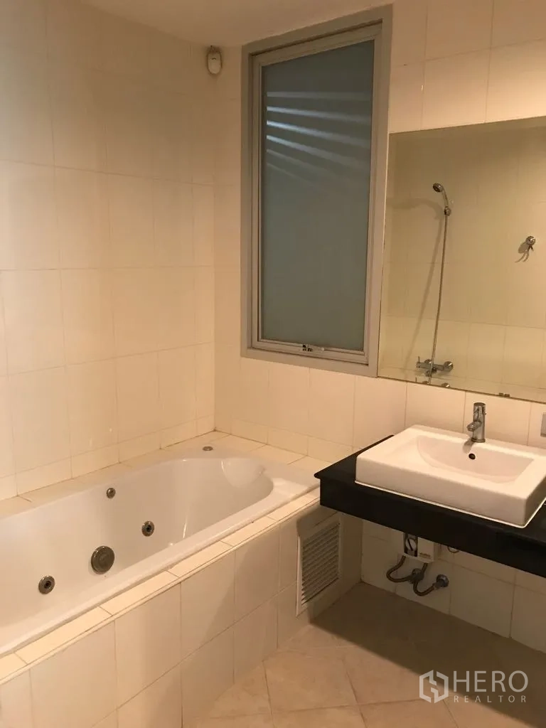 Condominium for rent in Watthana, Bangkok - Bathroom with built-in bathtub, large mirror and square basin