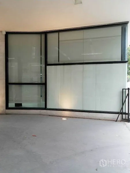 พื้นที่ขายปลีก ให้เช่าในKhlong Toei, Bangkok - กระจกหน้าร้านแบบโค้งเต็มความสูง กรอบอลูมิเนียมสีดำริมทางเท้า