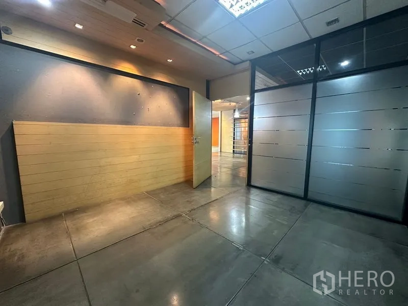 Office Space for rent in Khlong Toei, Bangkok - Hallway or reception room with wood wall panels, frosted glass and polished floors.