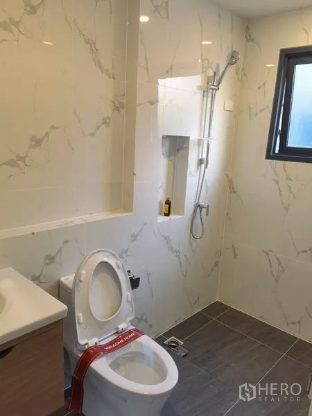 Detached House for rent in Bang Phli, Samut Prakan - Second bathroom with marble-look tiles, vanity and a shower niche.