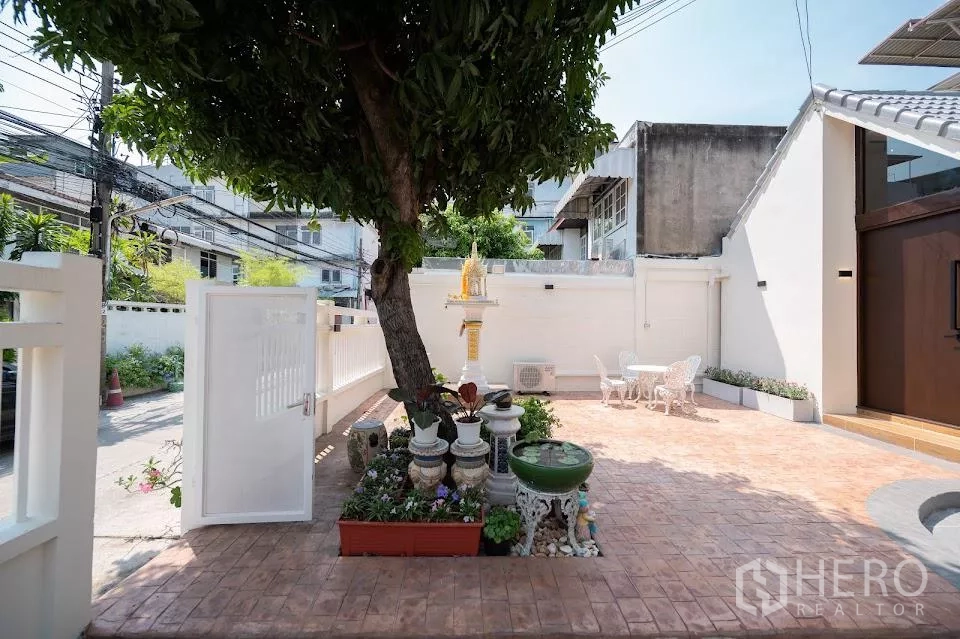 บ้าน ให้เช่าในPhra Khanong, Bangkok - ลานหน้าบ้านมีต้นไม้ใหญ่ ศาลพระภูมิ กระถางต้นไม้ และประตูสู่ถนน