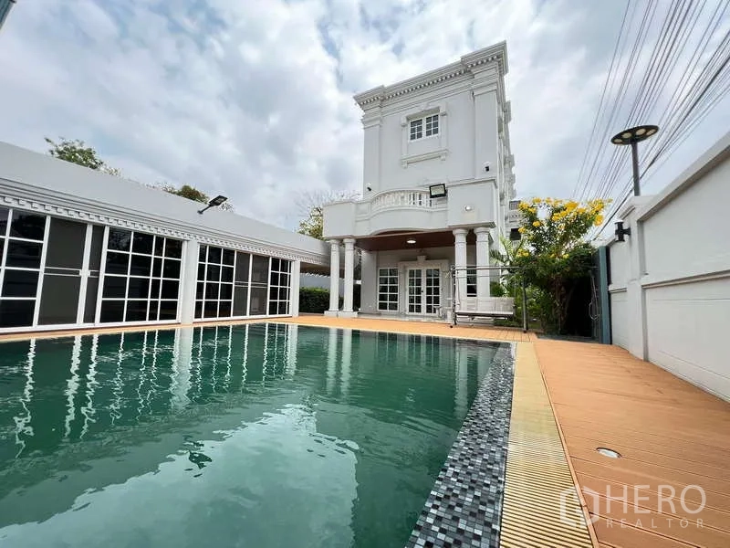 Detached House for rent in Bang Phli, Samut Prakan - Private swimming pool beside a neoclassical two‑storey house with columns and terrace.