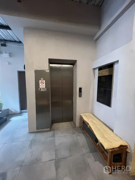 พื้นที่ขายปลีก ให้เช่า - โถงอาคารพร้อมลิฟต์สเตนเลส ม้านั่ง และพื้นกระเบื้องแผ่นใหญ่