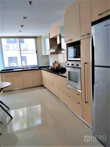 Condominium for rent in Bang Rak, Bangkok - Separate modern kitchen with built-in ovens, gas hob, and refrigerator.