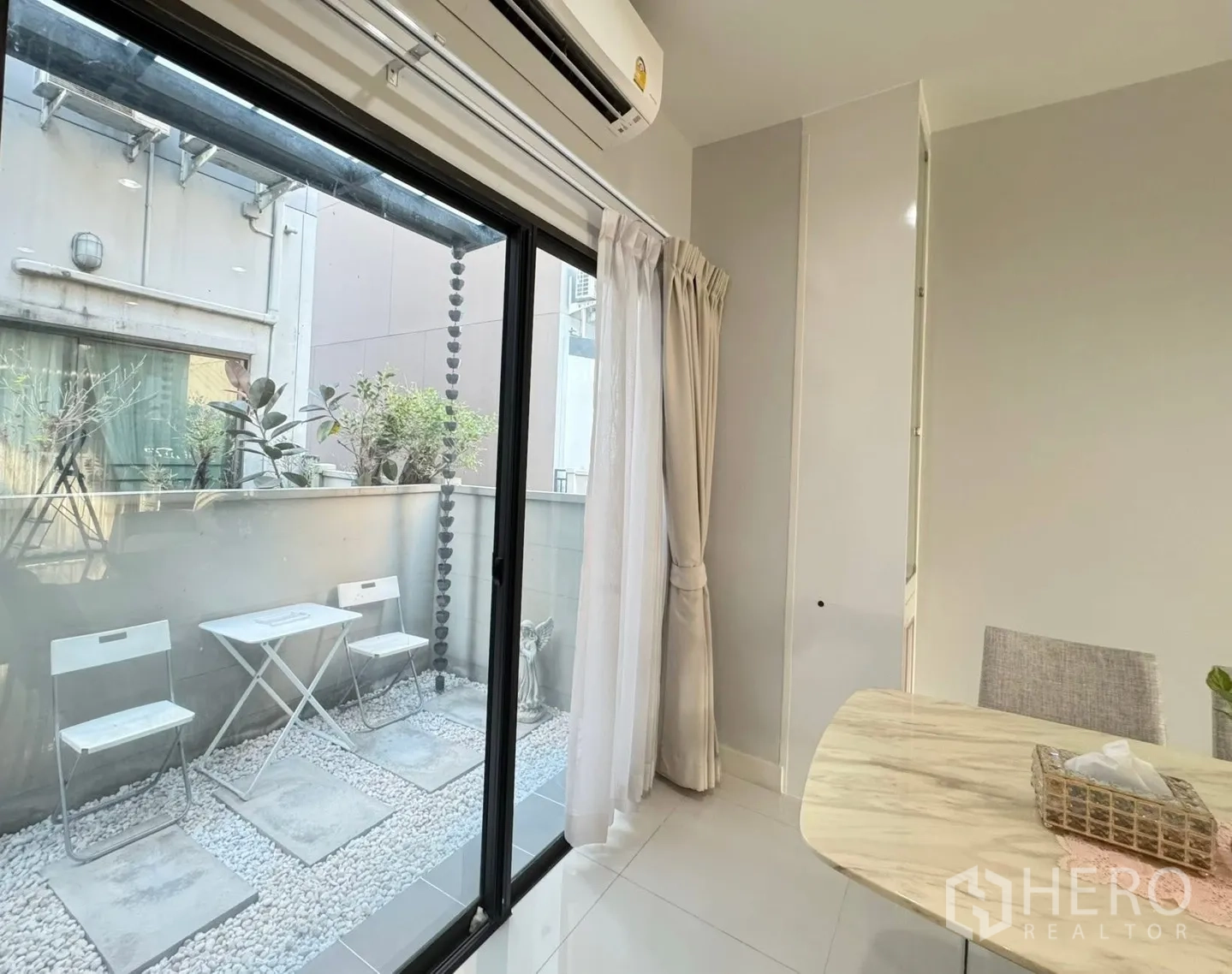 Townhouse for rent in Saphan Sung, Bangkok - Sliding glass doors open to a small gravel patio with bistro set.