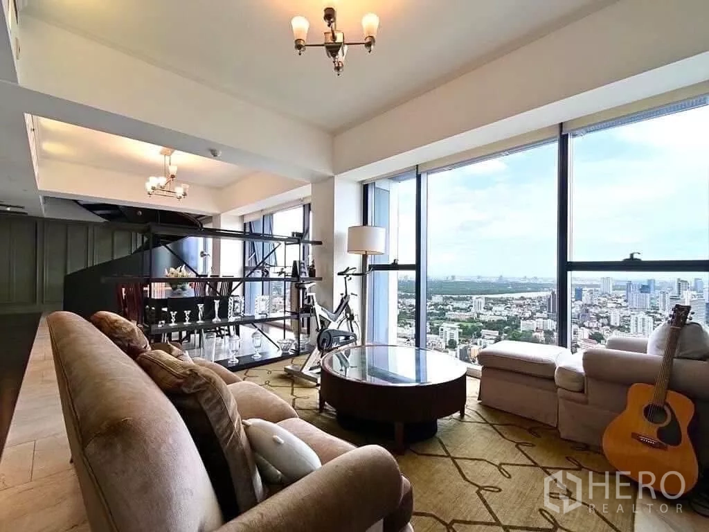Condominium for rent in Sathon, Bangkok - Cozy sitting zone by full-height windows with skyline view, round table and display shelving.