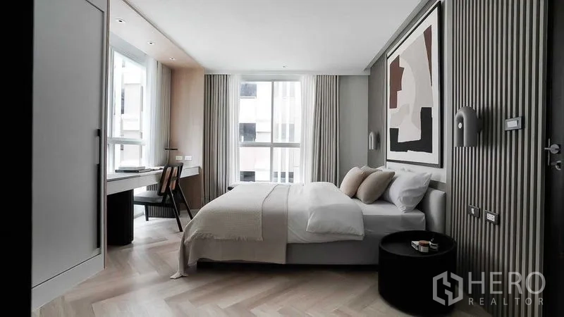 คอนโด ขายในRatchathewi, Bangkok - ห้องนอนใหญ่มีภาพศิลปะขนาดใหญ่ โต๊ะทำงานริมหน้าต่าง และพื้นลายก้างปลา