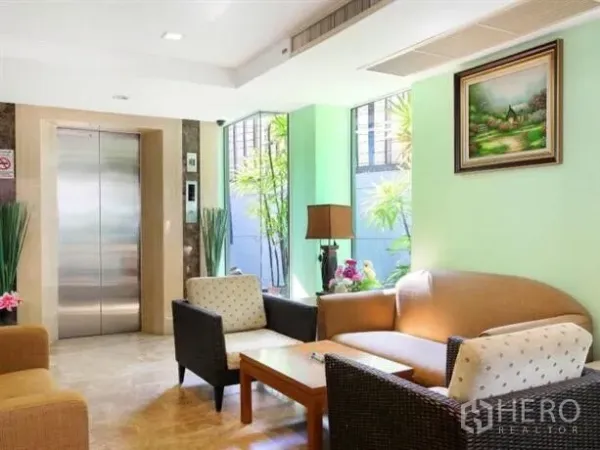 Apartment for sale in Ratchathewi, Bangkok - Cozy lobby corner with elevator access, sofa seating, and large windows.