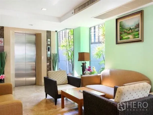 Apartment for sale in Ratchathewi, Bangkok - Cozy lobby corner with elevator access, sofa seating, and large windows.