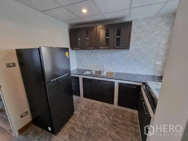 独立式住宅 出租在Mueang Nonthaburi, Nonthaburi - 第二厨房，双水槽、深色橱柜、瓷砖墙面及冰箱。