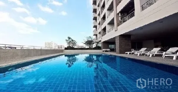 คอนโด ให้เช่าในPhaya Thai, Bangkok - สระว่ายน้ำกลางแจ้งกระเบื้องสีน้ำเงินพร้อมเตียงอาบแดดข้างอาคารคอนโด