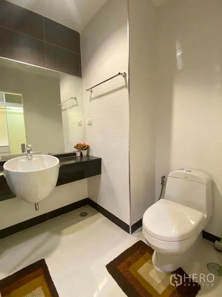 คอนโด ให้เช่าหรือขายในBang Kapi, Bangkok - ห้องน้ำที่สองพร้อมอ่างล้างหน้าทรงแขวน โถสุขภัณฑ์ และรายละเอียดท็อปสีดำ