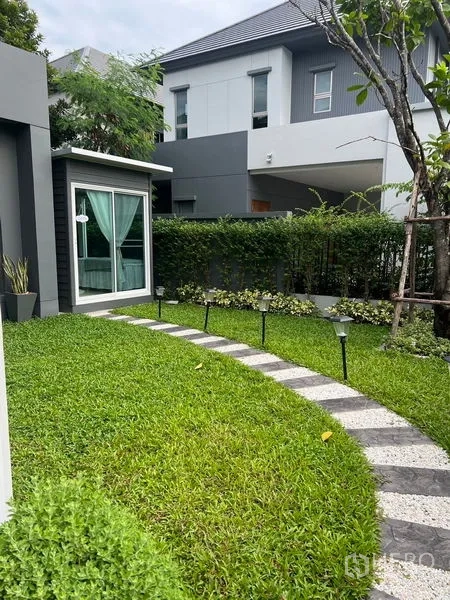 Detached House for sale in Bang Kapi, Bangkok - Private lawn with curved walkway and a detached glass garden room.