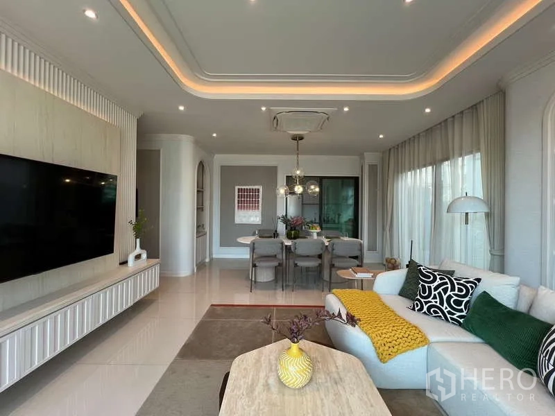 Detached House for sale in Saphan Sung, Bangkok - Open-plan living and dining area with feature TV wall and ceiling mood lighting.