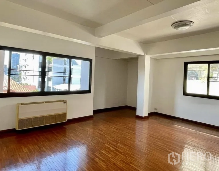 สำนักงานที่บ้าน ให้เช่าในKhlong Toei, Bangkok - ห้องมุมพร้อมหน้าต่างบานใหญ่ พื้นไม้ และเครื่องปรับอากาศติดผนัง