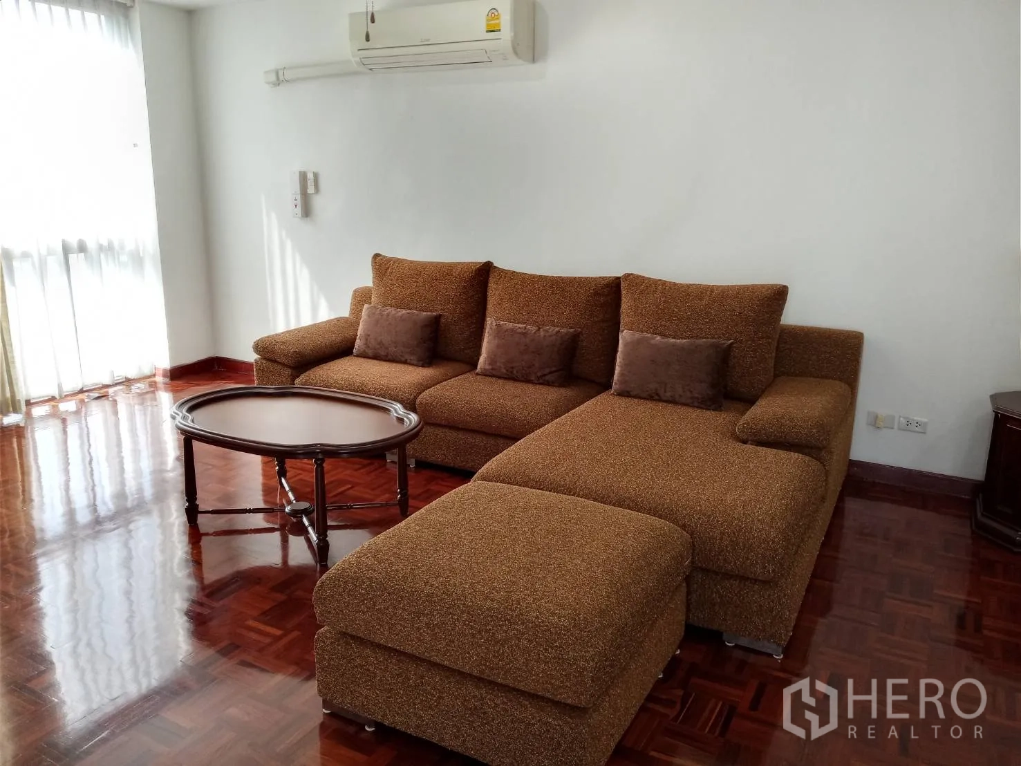 อพาร์ทเมนท์ ให้เช่าในWatthana, Bangkok - ห้องนั่งเล่นสว่าง เฟอร์นิเจอร์โซฟาเข้ามุมสีน้ำตาล โต๊ะกลาง และพื้นปาร์เกต์เงางาม